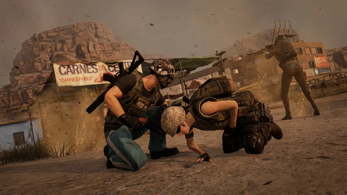 Σκηνή μάχης στο PUBG: BATTLEGROUNDS, δύο παίκτες σκύβουν κοντά σε λεηλατημένο εξοπλισμό ενώ ένας τρίτος πυροβολεί από απόσταση σε ερειπωμένη πόλη.